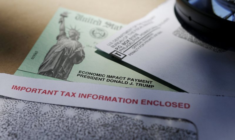 In this April 23, 2020, photo, President Donald Trump's name is seen on a stimulus check issued by the IRS to help combat the adverse economic effects of the COVID-19 outbreak, in San Antonio. The US government has distributed about 130 million economic impact payments to taxpayers in less than 30 days. The IRS anticipates sending more than 150 million payments as part of a massive coronavirus rescue package. (AP Photo/Eric Gay)