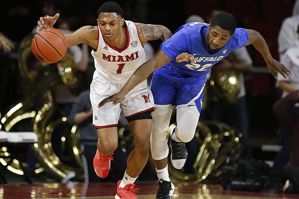Miami (Ohio) guard Nike Sibande (1) and Buffalo guard Dontay Caruthers, right, chase a loose ball during the first half of an NCAA college basketball game, Friday, March 1, 2019, in Oxford, Ohio. (AP Photo/Gary Landers)

