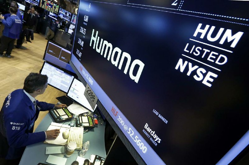 A specialist works adjacent to the post that handles shares of Humana on the floor of the New York Stock Exchange in this file photo. Humana said Tuesday that it is waiving deductibles and other out-of-pocket costs for all Medicare Advantage customers who visit their primary care doctor or see a behavioral health specialist. 
(AP) 