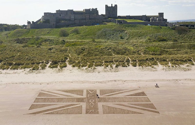 Andrew Heeley, a maintenance manager at Bamburgh Castle at Northumberland on the northeast coast of England, sculpts a giant United Kingdom flag on the beach Thursday ahead of today’s commemorations of the 75th anniversary of the Allied victory in the war in Europe. More photos at arkansasonline.com/58veday/.
(AP/Owen Humphreys)