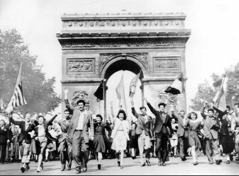 Parisians march through the Arc de Triomphe jubilantly waving flags of the Allied Nations as they celebrate the end of World War II on May 8, 1945.
(AP file photo)