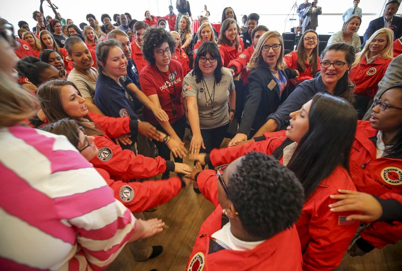 In October 2016, City Year and Americorp Arkansas members place their hands together in a circle for a final unity chant after pledging to serve communities of Arkansas for one year. (Democrat-Gazette file photo)