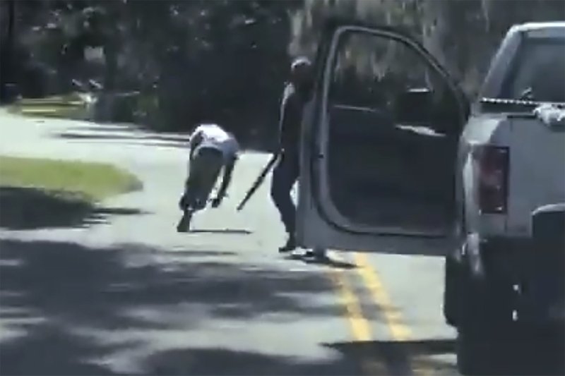 This image from video posted on Twitter Tuesday, May 5, 2020, purports to show Ahmaud Arbery stumbling and falling to the ground after being shot as Travis McMichael stands by holding a shotgun in a neighborhood outside Brunswick, Ga., on Feb. 23, 2020. The AP has not been able to verify the source of the video. (Twitter via AP)