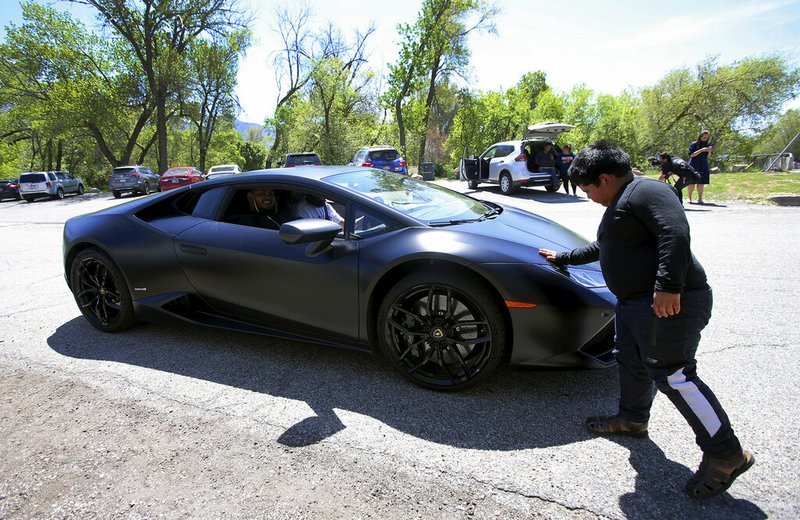 Adrian Zamarripa touches the front of Jeremy Neves' Lamborghini Huracan in Ogden, Utah, on Tuesday, May 5, 2020. Adrian had tried to drive his parents' car to California on May 4 and was stopped by the Utah Highway Patrol. Neves heard what had happened, and drove from another county to offer Adrian a ride.