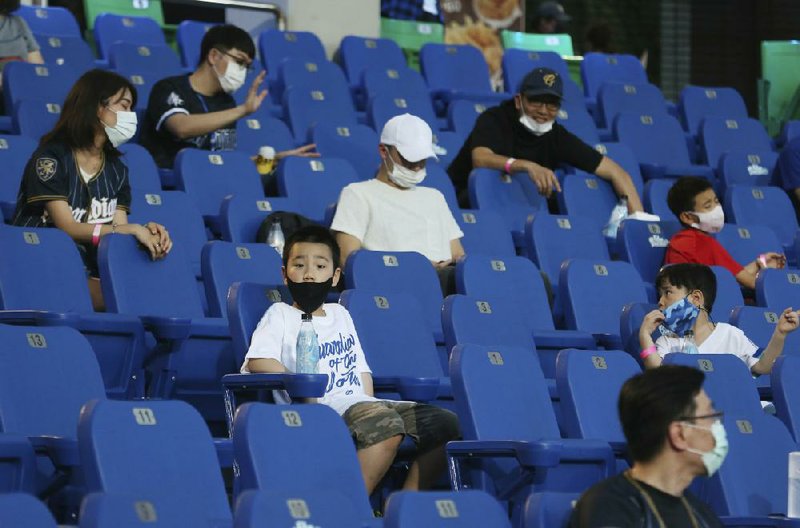 Fans sit in the stands for a game at Xinzhuang Baseball Stadium in New Taipei City, Taiwan, on Friday. Up to 1,000 spectators are now allowed in the stands for baseball in Taiwan, but concession stands are still closed.
(AP/Chiang Ying-ying)