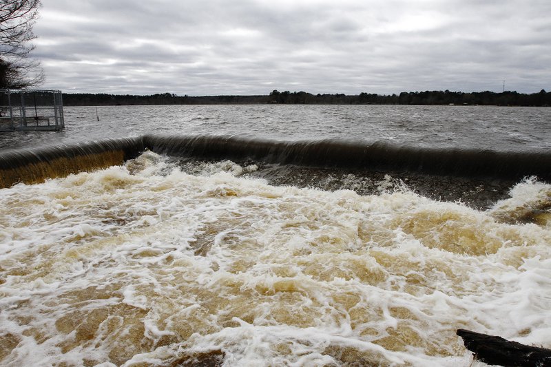 This December 2015 file photo shows an overflow of water from Calion Lake filling a basin after storms brought heavy rains to the area. The city began the installation process on  a new sewer system for residents on the south side of the lake in 2013; now, some residents say they've cut their utilities off since being connected to the new system, but they are still being billed for sewer usage. 