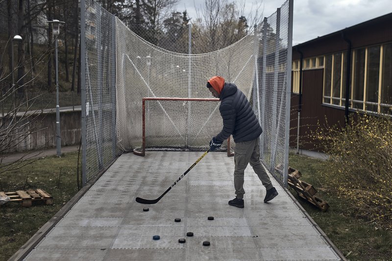 A young man practices hockey in Husby district, Rinkeby-Kista borough in Stockholm, Sweden, Tuesday, April 28, 2020. The coronavirus has taken a disproportionate toll among Sweden's immigrants. Many in these communities are more likely to live in crowded households and are unable to work remotely. There also are concerns the message has not reached everyone in immigrant neighborhoods. (AP Photo/Andres Kudacki) story.lead_photo.caption