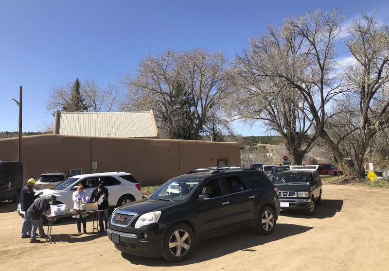 Cars line up for coronavirus testing at the Native American community of Picuris Pueblo, N.M., Thursday, April 23, 2020. Pueblo leaders including Gov. Craig Quanchello see COVID-19 as a potentially existential threat for the pueblo of just over 300 members and have implemented universal testing. . (AP Photo/Morgan Lee)