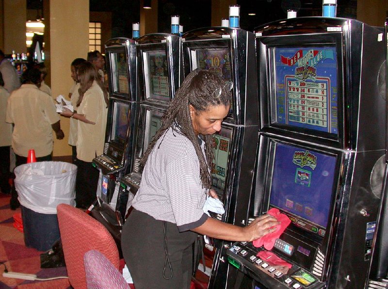 Ollie Dyson cleans a slot machine at Southland Gaming and Racing in West Memphis in this undated file photo.
