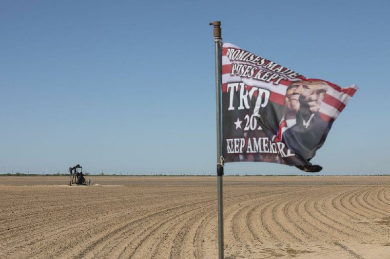 A pump jack works near a Trump 2020 flag flying at a private ranch in Midland, Texas, in April. The price for the U.S. benchmark for crude oil, West Texas Intermediate, dropped below zero for the first time in history last month amid a global oil glut.
(Matthew Busch/Bloomberg)