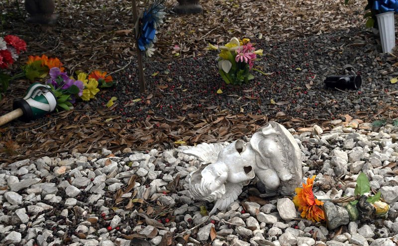 A memorial lies broken on a grave site at Cutter Morning Star Cemetery on Monday, which family members says was the result of vandalism the night before. - Photo by Grace Brown of The Sentinel-Record