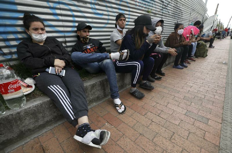 Venezuelan migrants wait last month for buses in Bogota, Colombia, to transport them to the border. They planned to return to their home country as coronavirus restrictions in Colombia prevented them from finding work. More photos at arkansasonline.com/511venezuela/. (AP/Fernando Vergara) 