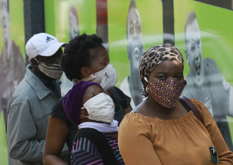 People line up Monday at a South African Social Security Agency office in Cape Town to collect government assistance as coronavirus cases rise. More photos at arkansasonline.com/512africa/ (AP/Nardus Engelbrecht) 