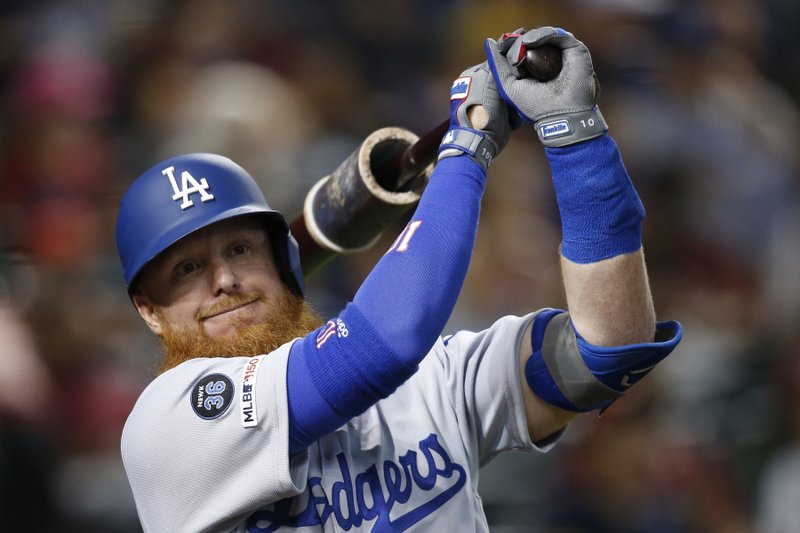 FILE - In this Aug. 29, 2019, file photo, Los Angeles Dodgers' Justin Turner warms up as he waits to bat against the Arizona Diamondbacks during the third inning of a baseball game in Phoenix. Turner is among older players who might see time at designated hitter if the National League uses it this season. (AP Photo/Ross D. Franklin, File)