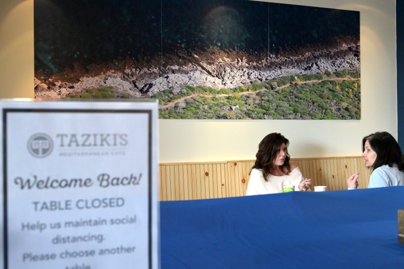 Carol Seago (left) and her friend Kim Magee dine in at Taziki's at 8200 Cantrell Road in Little Rock, where the dining room reopened Monday.

(Arkansas Democrat-Gazette / Stephen Swofford)



