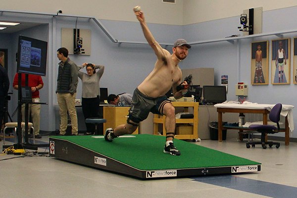 Central Connecticut pitcher Michael DeLease throws off a smart mound at the Center for Motion Analysis in Farmington, Conn. on Tuesday, Jan. 28, 2020. The new technology allows scientists to better study pitching mechanics to enhance efficiency and prevent injuries. (AP Photo/Pat Eaton-Robb)