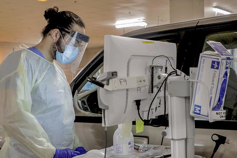 FILE — UAMS Doctor Andres Dias-Ortiz and other staff, along with National Guard medics, performed covid-19 tests at UAMS May 15 in Little Rock.