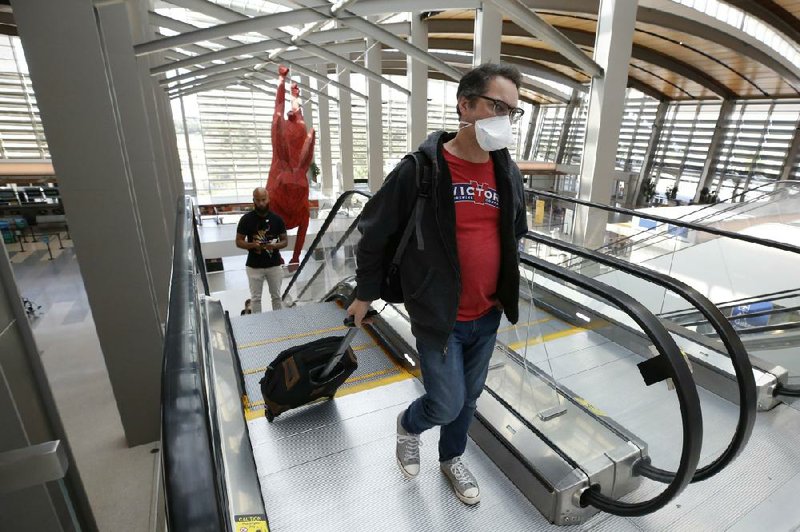 Southwest Airlines passenger Robert Civettini, who is properly masked, heads to his boarding gate earlier this week at Sacramento International Airport in California. More photos are available at arkansasonline.com/516mask/
(AP/Rich Pedroncelli)