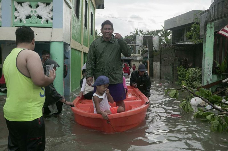 People use a boat for travel Friday after rains from Typhoon Vongfong flooded a village in northeastern Philippines.
(AP/Melchor Hilotin)
