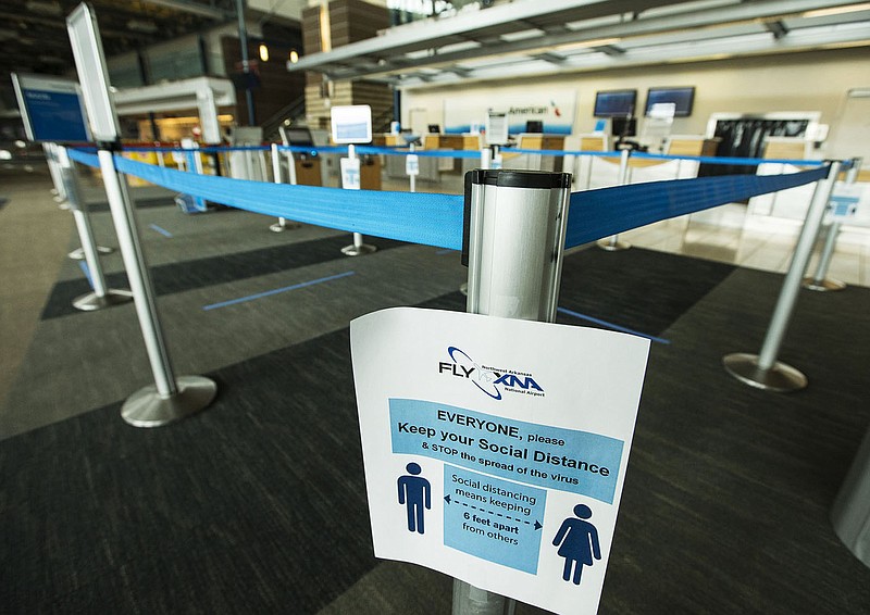 A sign asks passengers to maintain social distancing in the check-in area at Northwest Arkansas National Airport in Highfill in this Wednesday, May 13, 2020, file photo. Go to nwaonline.com/200517Daily/ to see more photos. (NWA Democrat-Gazette/Ben Goff)
