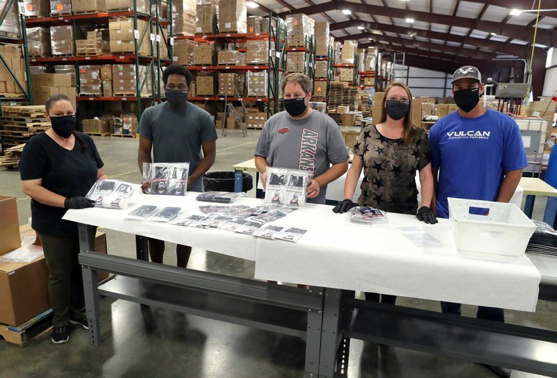 Employees of Vulcan Sporting Goods Co. and its parent company, Tanners Team Sports, from left, Sheila Lamera, Akiel Byers, Justin McDaniel, Gina Andrews and Brandon Nugent, display new face masks the company is manufacturing that are designed for athletes and fans to control the spread of the coronavirus. - Photo by Richard Rasmussen of The Sentinel-Record