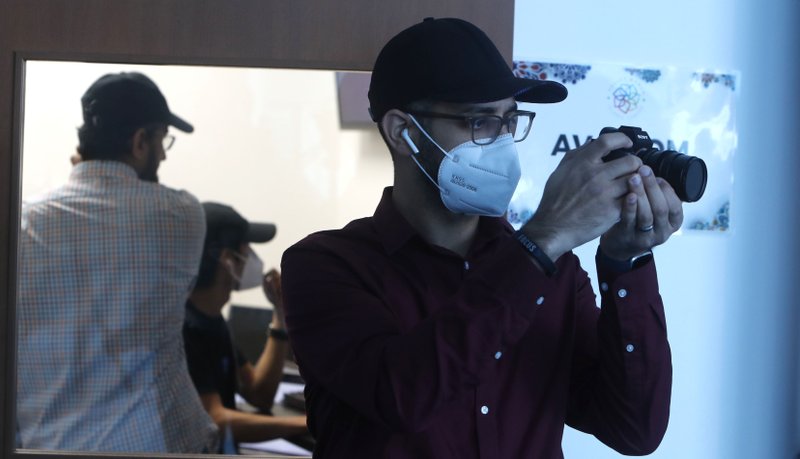 Head of video production Fawzi Yahya shoots still photos during an online broadcast from the Valley Ranch Islamic Center mosque in Irving, Texas, Wednesday, May 13, 2020. (AP Photo/LM Otero)