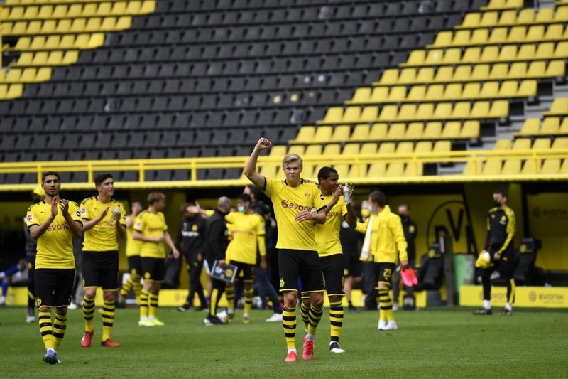 Dortmund's Erling Haaland, center, and his teammates celebrate at the end of the German Bundesliga soccer match between Borussia Dortmund and Schalke 04 in Dortmund, Germany, Saturday, May 16, 2020. The German Bundesliga becomes the world's first major soccer league to resume after a two-month suspension because of the coronavirus pandemic. Dortmund won 4-0. (AP Photo/Martin Meissner, Pool)