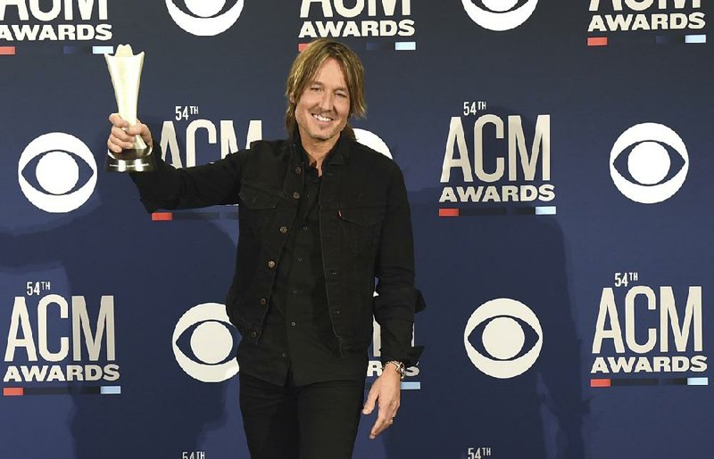 FILE - In this April 7, 2019, file photo, Keith Urban poses in the press room with the award for entertainer of the year at the 54th annual Academy of Country Music Awards in Las Vegas. The Academy of Country Music had to postpone its upcoming awards show, to be hosted by Urban, because of the spreading coronavirus, but CBS will air a new television special featuring country stars performing from their homes. (Photo by Jordan Strauss/Invision/AP, File)