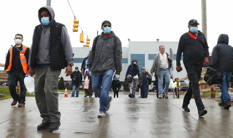 United Auto Workers members leave the Fiat Chrysler Automobiles Warren Truck Plant after the first work shift, Monday, May 18, 2020, in Warren, Mich.