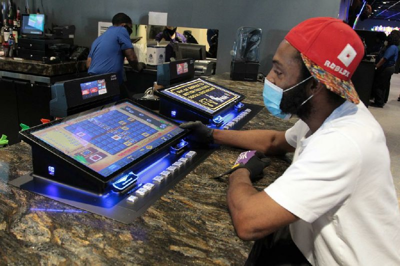 Ricky Jones of Pine Bluff tries his luck Monday, May 18, 2020, at one of the video poker machines that line the bar at Saracen Casino Annex. Jones was one of the first people through the door that morning. More photos at arkansasonline.com/519casino/. (Arkansas Democrat-Gazette/Dale Ellis) 