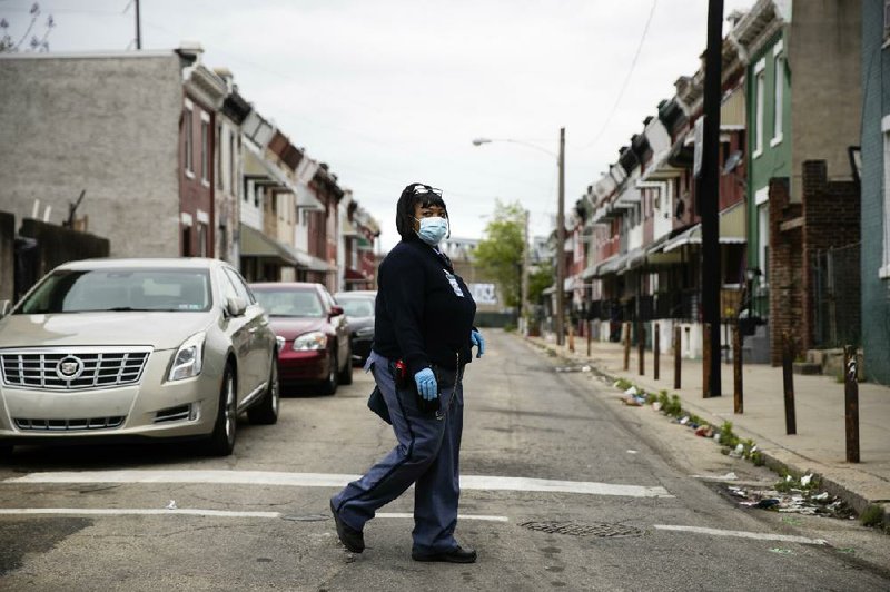 U.S. Postal Service carrier Henrietta Dixon walks her route earlier this month in Philadelphia. (AP/Matt Rourke) story.lead_photo.caption