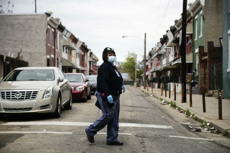 U.S. Postal Service carrier Henrietta Dixon walks her route earlier this month in Philadelphia. (AP/Matt Rourke)