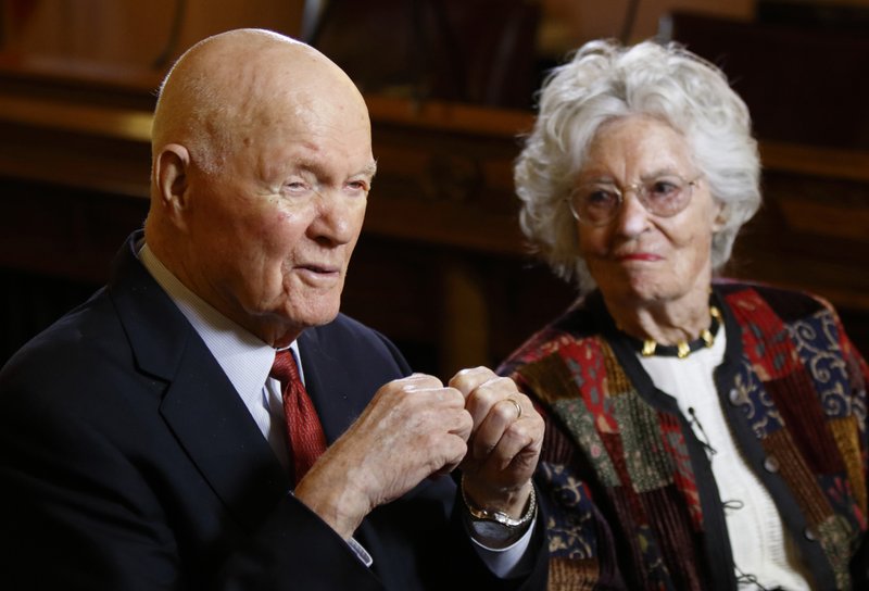 FILE - In this May 14, 2015, file photo, former astronaut and U.S. Sen. John Glenn, D-Ohio, left, answers questions with his wife Annie Glenn during an interview with The Associated Press at the Ohio Statehouse in Columbus, Ohio. Glenn, the widow of John Glenn and a communication disorders advocate, died Tuesday, May 19, 2020, of COVID-19 complications at a nursing home near St. Paul, Minn., at age 100. (AP Photo/Paul Vernon, File)