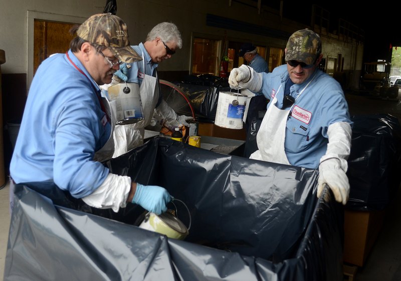 Clean Harbors workers box up waste material collected from El Dorado and Union County residents during a household hazardous waste collection day at Clean Harbors In April 2015. (News-Times file)