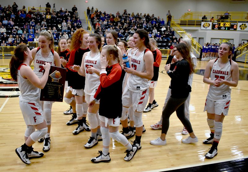 MARK HUMPHREY ENTERPRISE-LEADER Farmington senior Kaci Drain celebrates with her teammates after accepting the 4A-1 District girls basketball championship trophy on Saturday, Feb. 22. Farmington defeated Pea Ridge, 51-39, in the semifinals and Harrison, 54-41, to claim first place in the tourney for the second straight year. Prairie Grove hosted the tournament at Tiger Arena.