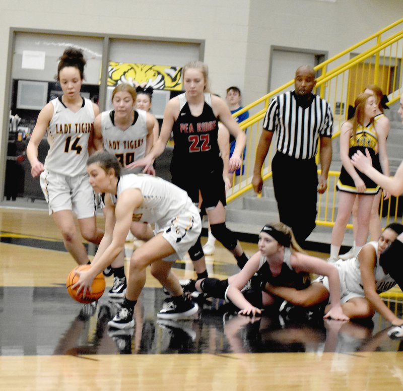 MARK HUMPHREY ENTERPRISE-LEADER Prairie Grove's Torie Price takes control after a collision jarred the ball loose with teammate Jasmine Wynos driving the lane during a very physical contest against Pea Ridge. Price scored 10 points, but the Lady Tigers lost 45-39 and were eliminated from the District 4A-1 tournament they hosted at Tiger Arena on Tuesday, Feb. 18.