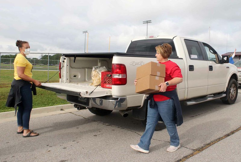 LYNN KUTTER ENTERPRISE-LEADER Melissa Parrish with Prairie Grove schools and Wendy Burrus with Farmington schools were two of about 55 volunteers at the Tyson Foods' Food Giveaway. Volunteers came from Lincoln, Farmington and Prairie Grove. In all, 115 pounds of food was given away to an estimated 2000 people.