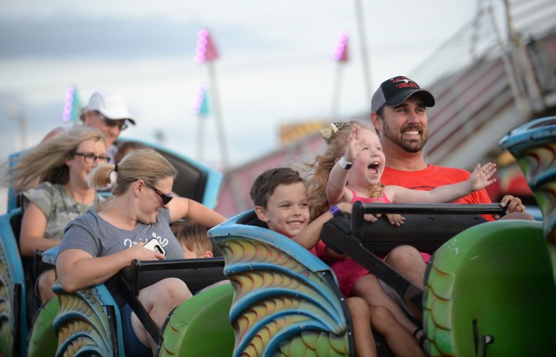 FILE -- Aaron Davis of Tontitown (right) smiles Friday, Aug. 9, 2019, as he rides The Cobra with his daughter, Nora Davis, and son, Hayes Davis, during the 121st Tontitown Grape Festival in Tontitown. (NWA Democrat-Gazette/ANDY SHUPE)