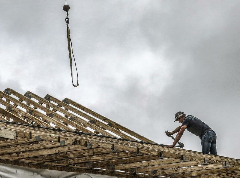 ith J.R.J. Construction secures a roof truss Tuesday atop a house going up near Ensor, Ky. The Commerce Depart- ment says new home construction starts nose-dived in April.
(The Messenger-Inquirer/Greg Eans)
 