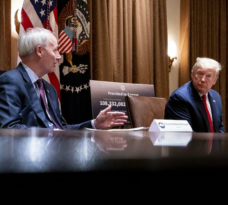 Gov. Asa Hutchinson tells President Donald Trump how Arkansas is faring in the coronavirus crisis at their meeting Wednesday at the White House. More photos at arkansasonline.com/521meeting/.
(The New York Times/Doug Mills)