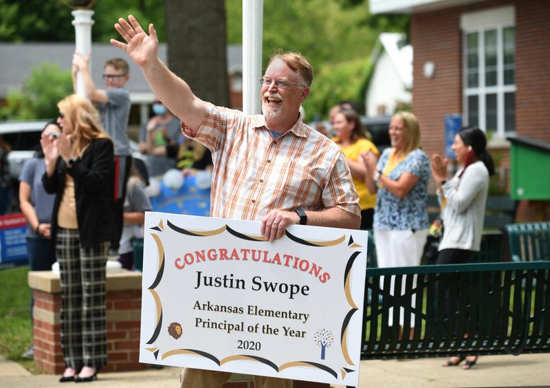 Lee Elementary School principal Justin Swope waves Thursday to passing well wishers from the parking lot of the school in Springdale. Swope was recognized as the Arkansas Elementary Principal of the Year 2020 by the Arkansas Association of Elementary School Principals. Swope has been the principal at Lee Elementary School for nine years. Go to nwaonline.com/200522Daily/ and nwadg.com/photos for a photo gallery. (NWA Democrat-Gazette/David Gottschalk)