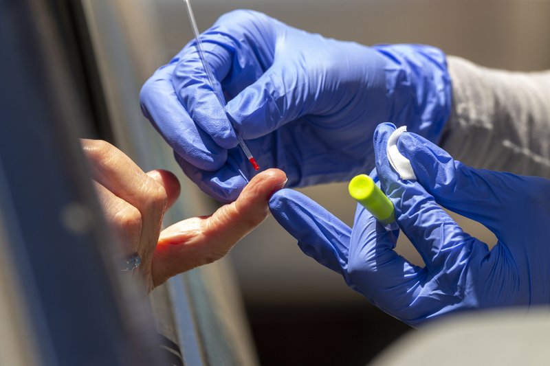 A health worker takes a blood sample for a COVID-19 antibody test Wednesday in Los Angeles. An antibody test might show if you had COVID-19 in the recent past, which most experts think gives people some protection from the virus. - AP Photo/Damian Dovarganes