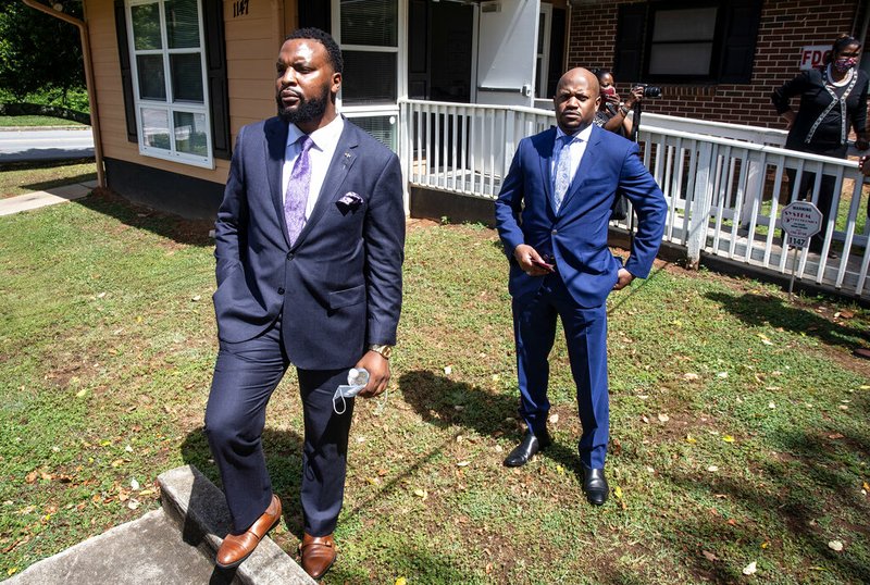 Lee Merritt, left, and Chris Stewart, attorneys for the mother of Ahmaud Arbery, are seen at a news conference on Wednesday, May 19, 2020, in East Point, Georgia. The attorneys appeared and spoke at a news conference held by the Atlanta branch of the NAACP. After a video of the shooting of Arbery emerged on social media, the Georgia Bureau of Investigation, arrested Gregory McMichael, 64, and his son, Travis McMichael, 34, and they were jailed on murder and aggravated assault charges. (AP Photo/Ron Harris) story.lead_photo.caption
