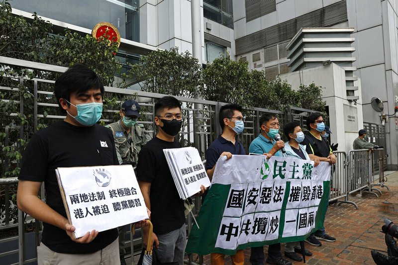 Members of the Democratic Party hold banner and placards during a protest in front of the Chinese central government's liaison office in Hong Kong, Friday, May 22, 2020. Hong Kong's pro-democracy lawmakers have sharply criticized China's move to take over long-stalled efforts to enact national security legislation in the semi-autonomous territory. They say it goes against the "one country, two systems" framework that promises the city freedoms not found on the mainland. The banner reads "Evil national security law destroys Hong Kong, Chinese Communists seek mutual destruction of one country two systems". (AP Photo/Kin Cheung)