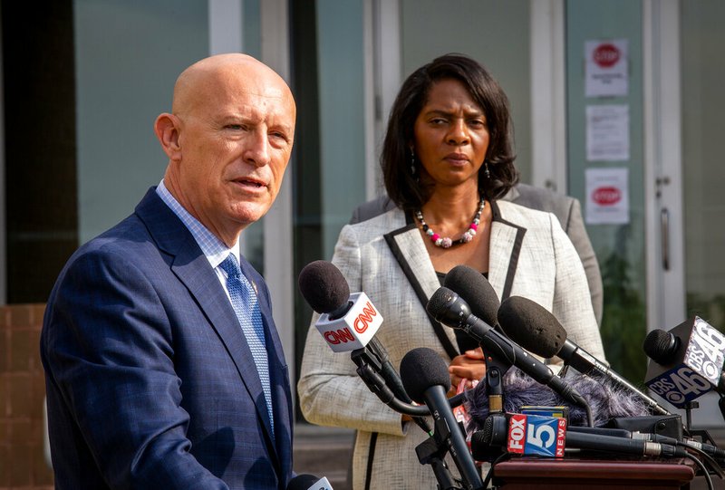 Vic Reynolds, director of the Georgia Bureau of Investigation, speaks to the press as Joyette Holmes, Cobb County District Attorney, looks on during a news conference Friday, May 22, 2020, in Decatur, Ga. Reynolds was announcing the arrest of William Bryan in connection with the death of Ahmaud Arbery.