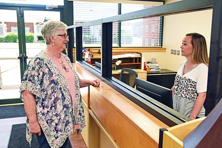 Deborah Moore, director of the Lonoke County Library System, left, visits with Ashlee Minson, the branch manager for the Lonoke Public Library. Moore said the library branches will begin a soft reopening phase Tuesday by opening their computer labs with social distancing and reservations.