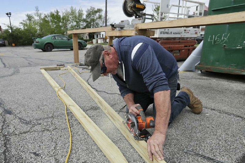 A worker cuts planks Thursday at a construction site in Lyndhurst, Ohio. More than 2.4 million people applied for U.S. unemployment benefits last week, in the latest wave of layoffs during the pandemic. More photos at arkansasonline.com/522job/
(AP/Tony Dejak)