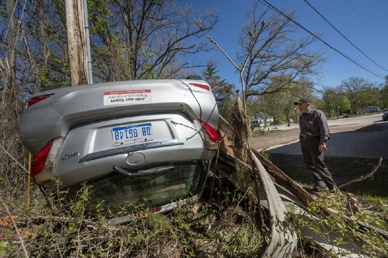 Rich Cobb, a mechanic, checks out a floodwaters-overturned delivery vehicle Thursday in Sanford, Mich.
(AP/Detroit News/David Guralnick)