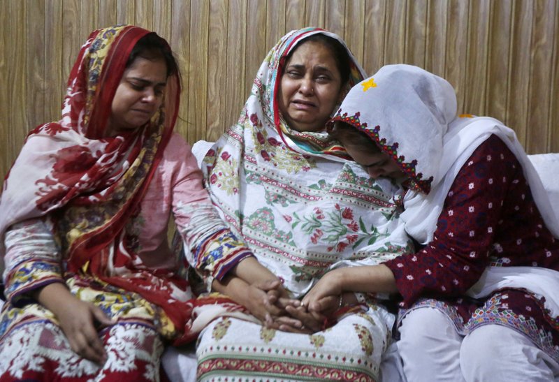 Family members of an air hostess Anam Maqsood, who was killed in Friday's plane crash, mourn for her death at their home in Lahore, Pakistan, Saturday, May 23, 2020. An aviation official says a passenger plane belonging to state-run Pakistan International Airlines carrying passengers and crew has crashed near the southern port city of Karachi. (AP Photo/K.M. Chaudary)