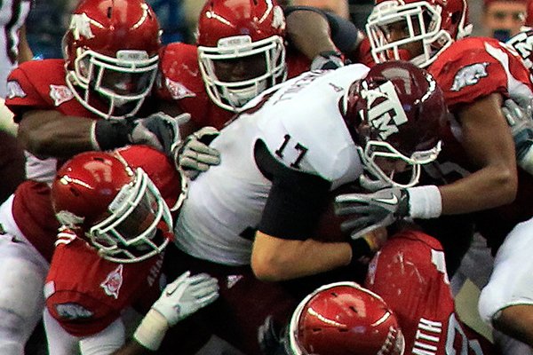 Arkansas defenders tackle Texas A&M quarterback Ryan Tannehill (17) during a game Saturday, Oct. 1, 2011, in Arlington, Texas. 